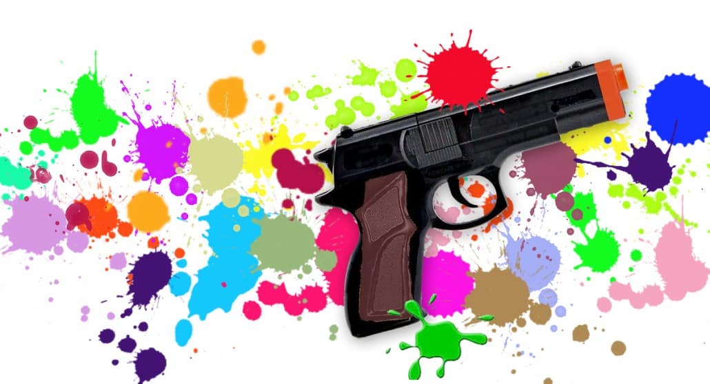 Toy gun on paint-splattered background