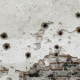 A wall marked with bullet holes