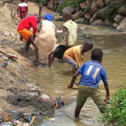 Photo of people taking water from an unclean stream