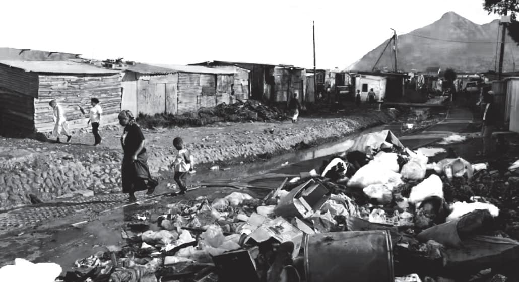 A photo of refuse and garbage piled in a township street