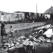 A photo of refuse and garbage piled in a township street